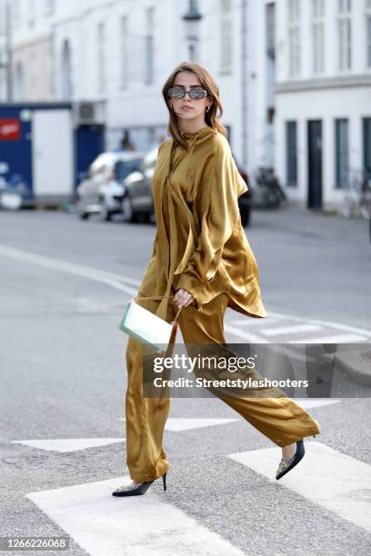 Influencer Sarah Lou Falk, wearing a golden suit by Lala Berlin, heels by Custommade, a mint colored bag by Louis Vuitton and sunglasses by Gucci...