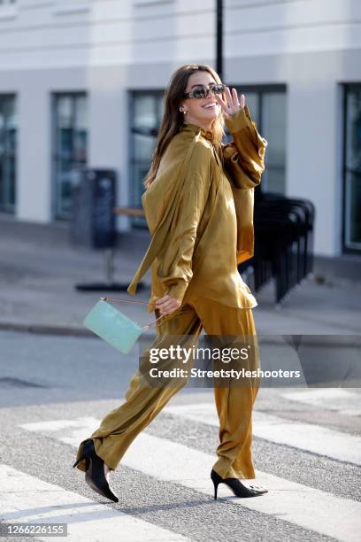 Influencer Sarah Lou Falk, wearing a golden suit by Lala Berlin, heels by Custommade, a mint colored bag by Louis Vuitton and sunglasses by Gucci...