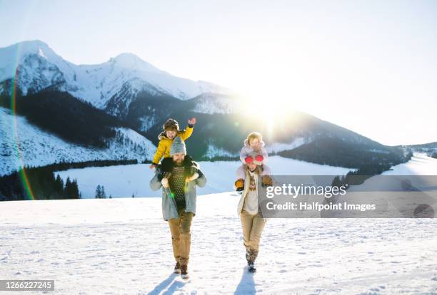 portrait of family with two small children enjoying snow in winter nature. - family in snow mountain stock-fotos und bilder