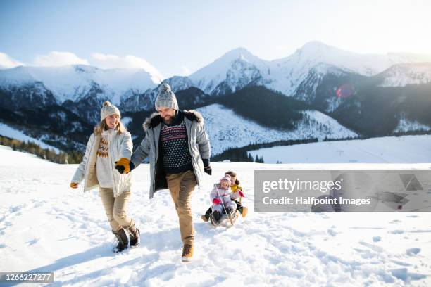 portrait of family with two small children enjoying snow in winter nature. - tatras slovakia stock pictures, royalty-free photos & images