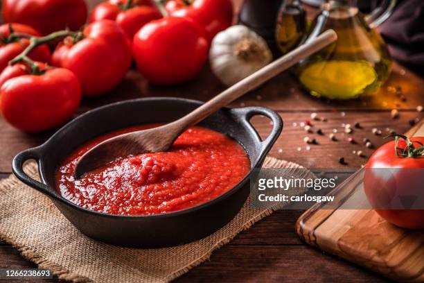 cooking and seasoning tomato sauce - savory sauce stock pictures, royalty-free photos & images