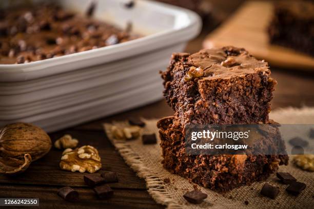 homemade chocolate brownie on a rustic wooden table - brownie stock pictures, royalty-free photos & images