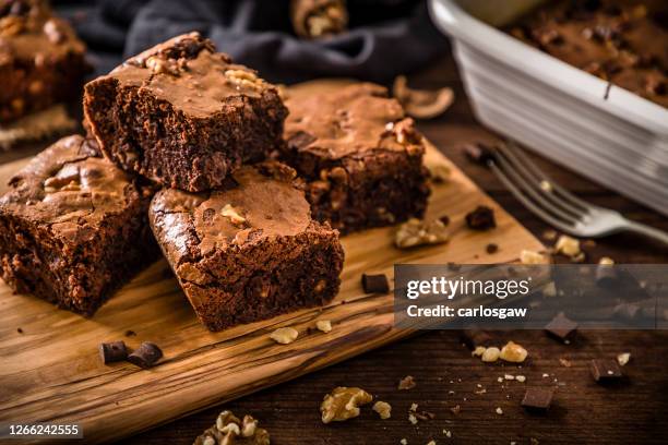 homemade chocolate brownie on a rustic wooden table - brownie stock pictures, royalty-free photos & images