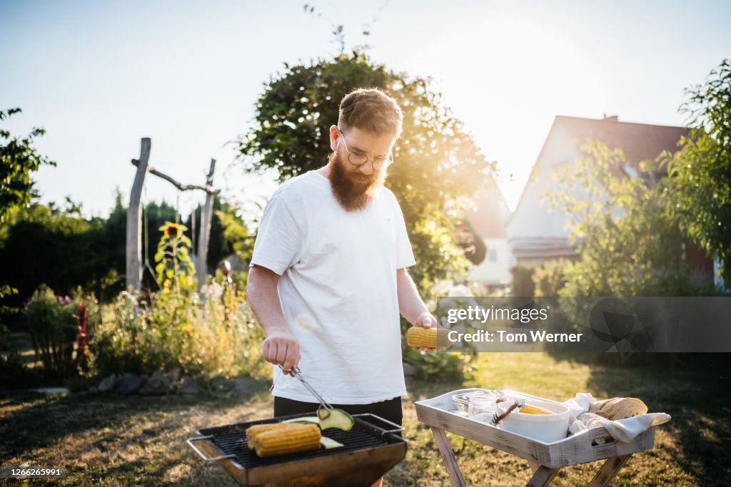 Father Preparing Food On BBQ For Family