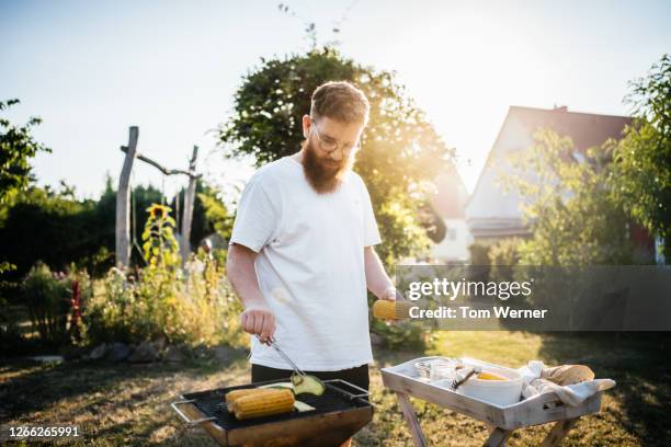 father preparing food on bbq for family - barbecue man stock pictures, royalty-free photos & images