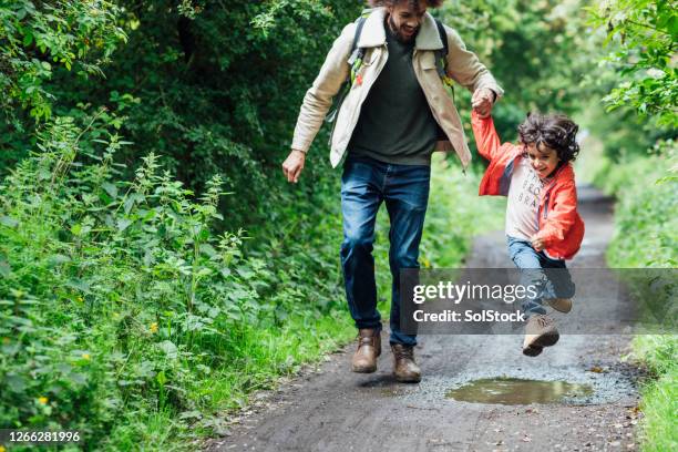 saltar en charcos - puddle fotografías e imágenes de stock