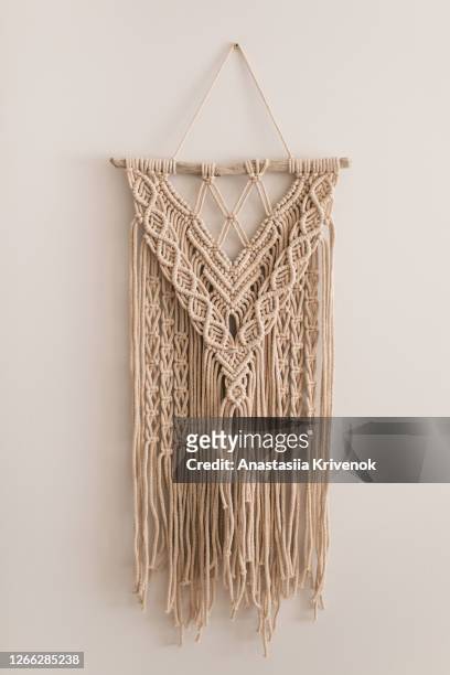 handmade natural cotton macrame derocation on the beige wall. stylish trendy eco accessory for home. handicraft and trendy concept. - macrame stock pictures, royalty-free photos & images