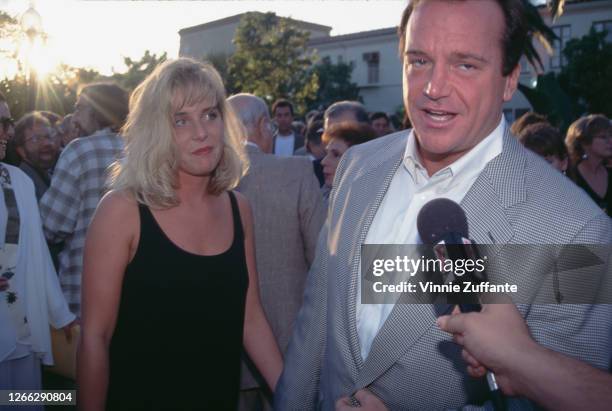 American actor and comedian Tom Arnold and his girlfriend Julie Lynn Champnella at the premiere of the film 'Clear and Present Danger' in Los...