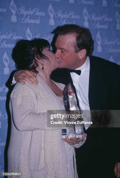 American actor and comedian Roseanne Barr kissing her husband, actor Tom Arnold after receiving the award for Favorite Female TV Performer at the...