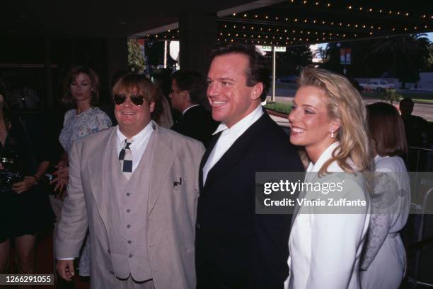 From left to right, actors Chris Farley and Tom Arnold and Arnold's wife Julie at the premiere of the film 'Nine Months' in Century City, Los...