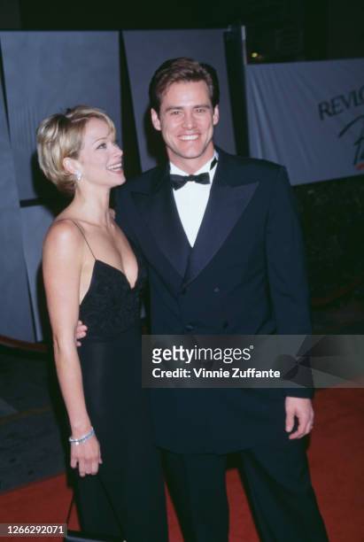 American actor Jim Carrey and his partner, actress Lauren Holly, at the 1996 Fire and Ice Ball at the Warner Brothers Studios in Hollywood,...