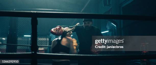 female boxer pad work session with trainer. quick punches in boxing ring - boxing trainer stock pictures, royalty-free photos & images