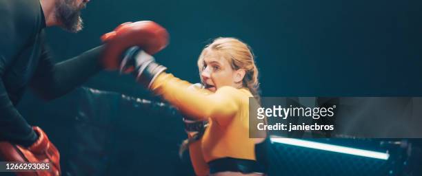 female boxer pad work session with trainer. quick punches - fast furious stock pictures, royalty-free photos & images