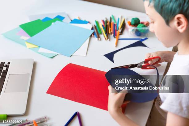 kid boy making hand made color paper card with on line lessons. - child cutting card stock pictures, royalty-free photos & images