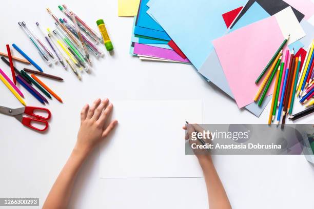 unkenntliche kinderhände zeichnen auf leerem papier. ansicht von oben - kids craft stock-fotos und bilder