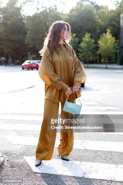 Influencer Sarah Lou Falk, wearing a golden suit by Lala Berlin, heels by Custommade and a mint colored bag by Louis Vuitton during a street style...