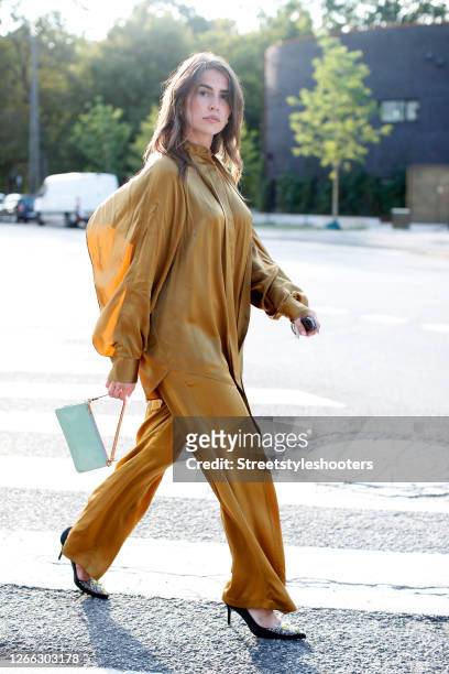 Influencer Sarah Lou Falk, wearing a golden suit by Lala Berlin, heels by Custommade and a mint colored bag by Louis Vuitton during a street style...