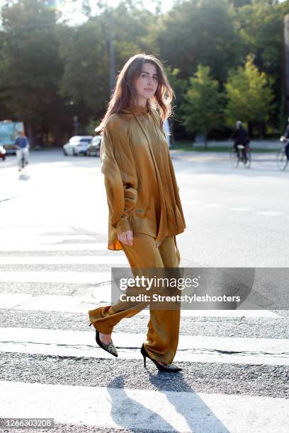 Influencer Sarah Lou Falk, wearing a golden suit by Lala Berlin, heels by Custommade and a mint colored bag by Louis Vuitton during a street style...