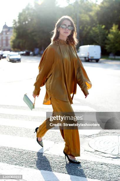 Influencer Sarah Lou Falk, wearing a golden suit by Lala Berlin, heels by Custommade, a mint colored bag by Louis Vuitton and sunglasses by Gucci...