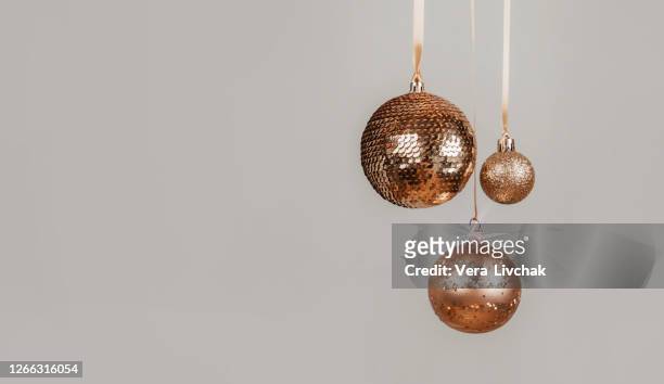 new year 2021. holyday concept. many golden christmas baubles hanging against the grey background. copy space. - three year stock pictures, royalty-free photos & images