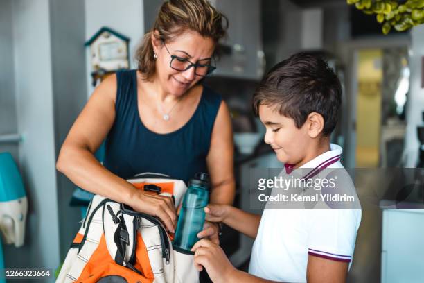 madre single che aiuta suo figlio a prepararsi per la scuola - preparazione foto e immagini stock