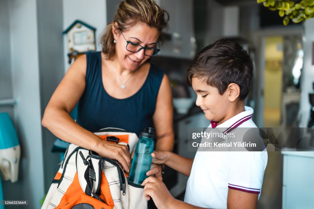 Single Mother helping her son get ready for school