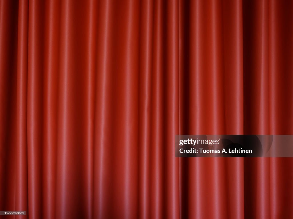 Front view of a folded red polyester curtain.