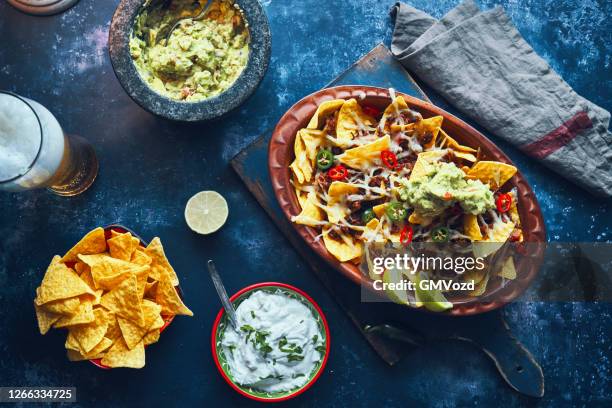 nachos with minced meat, hot salsa and guacamole - nachos guacamole stock pictures, royalty-free photos & images