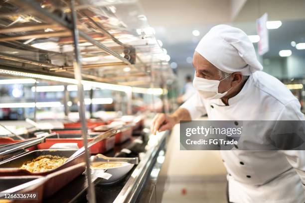 chef checking food on the buffet - cafeteria stock pictures, royalty-free photos & images