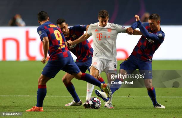 Robert Lewandowski of FC Bayern Munich is challenged by Luis Suarez, Sergio Busquets, and Clement Lenglet of FC Barcelona during the UEFA Champions...