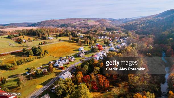 vista aérea de la pequeña ciudad rodeada por el bosque en la montaña en otoño por la mañana. - pennsylvania fotografías e imágenes de stock