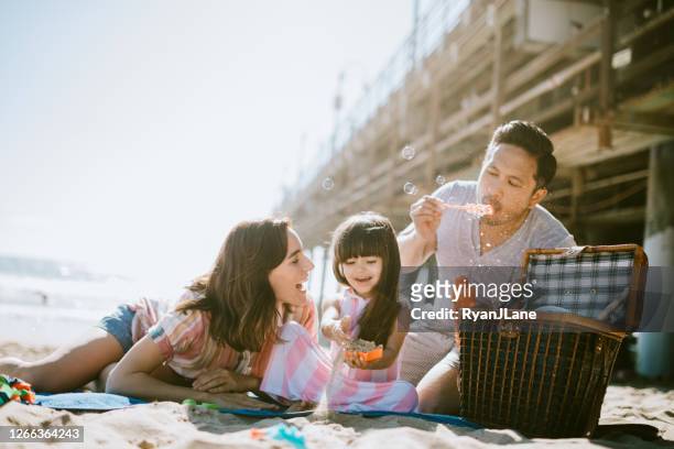 loving family enjoying sun at los angeles beach - beach picnic stock pictures, royalty-free photos & images