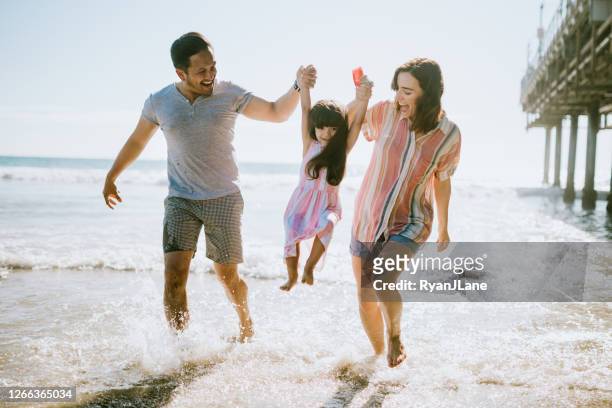 het houden van familie die van zon bij het strand van los angeles geniet - young family outdoors stockfoto's en -beelden