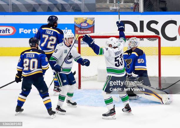 Elias Pettersson of the Vancouver Canucks celebrates his power-play goal at 5:36 of the third period against the St. Louis Blues and is joined by Bo...