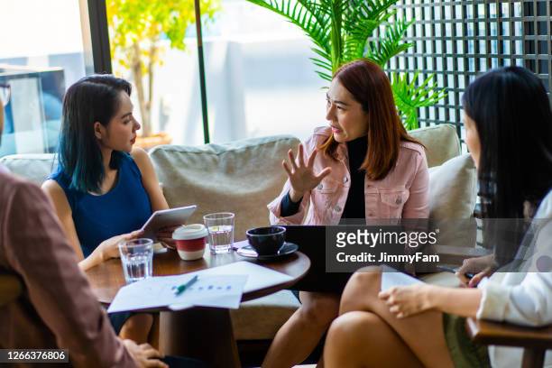 asians millennials discussing work in coworking space. - southeast stock pictures, royalty-free photos & images