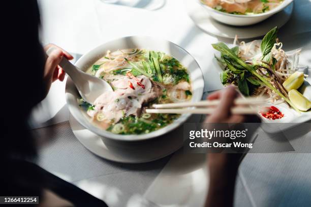 woman eating vietnamese pho soup with noodles and beef - female eating chili bildbanksfoton och bilder