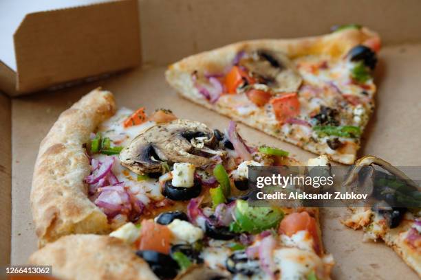 slices of italian vegetable pizza with cheese and mushrooms in a cardboard box or packaging for delivery, on a wooden table in a cafe or pizzeria. vegetarian food. fast food. - parmesan cheese pizza stock pictures, royalty-free photos & images