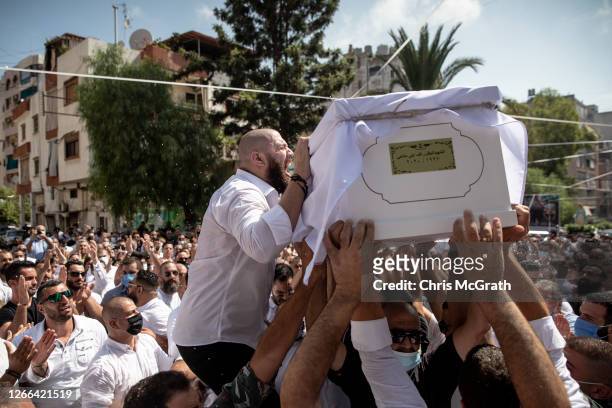 The brother of 23-year-old firefighter Ralph Malahi who was killed in the August 4, Beirut port explosion, reacts while his coffin is carried by...