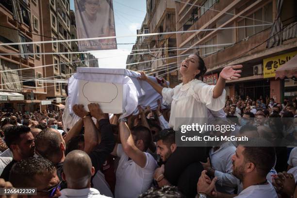 The sister of 23-year-old firefighter Ralph Malahi who was killed in the August 4, Beirut port explosion, reacts while his coffin is carried by...