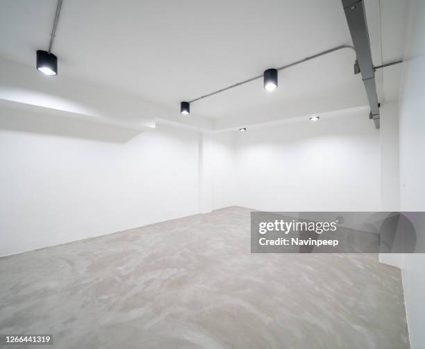 white studio space with lighting, white wall, concrete floor - empty art gallery stock pictures, royalty-free photos & images