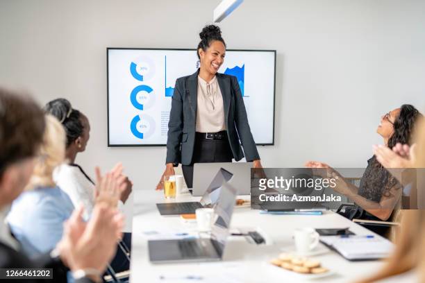 multi-ethnic executive team applauding female ceo in meeting - colleague appreciation stock pictures, royalty-free photos & images