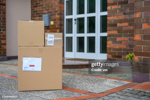 cardboard packages on the floor at the doorstep of a house - doorstep stock pictures, royalty-free photos & images