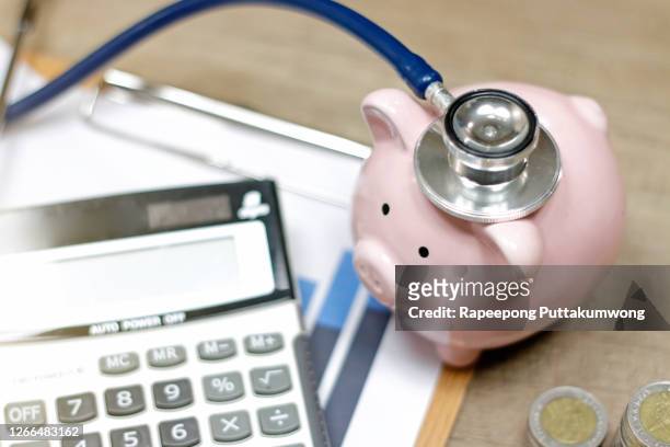 stethoscope and calculator symbol for health care costs or medical insurance - seguro médico fotografías e imágenes de stock