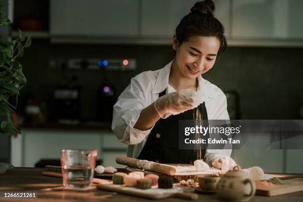 an asian chinese beautiful woman making chinese traditional mid-autumn snow skin mooncake at her kitchen - mooncake stock pictures, royalty-free photos & images