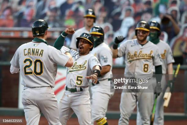 Mark Canha of the Oakland Athletics is congratulated by Tony Kemp after he hit a three-run home run on the ninth inning against the San Francisco...