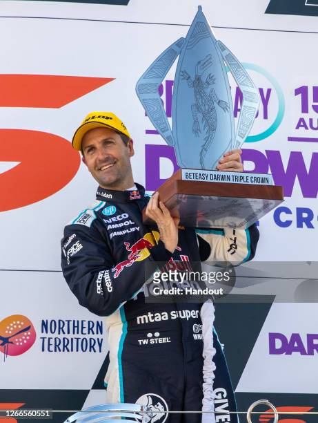 In this handout photo provided by Edge Photographics, Jamie Whincup driver of the Red Bull Holden Racing Team Holden Commodore ZB poses after winning...