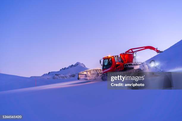 toiletteur de neige rouge sur la pente de ski pendant le crépuscule - environmental damage photos et images de collection