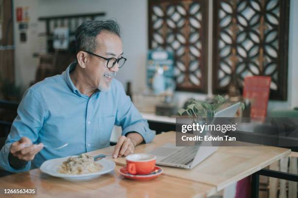 an asian chinese senior man having discussion with his colleague via online virtual meeting in a cafe - virtual lunch stock pictures, royalty-free photos & images