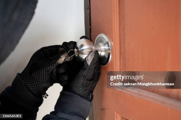 masked thief using lock picker to open locked door - burglar stock pictures, royalty-free photos & images
