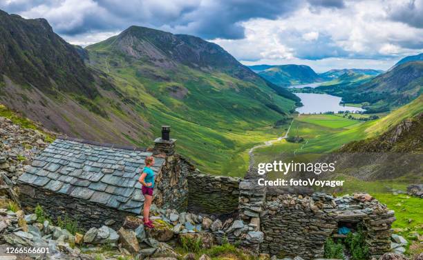 woman trail runner overlooking mountain valley bothy lake district panorama - lakeland stock pictures, royalty-free photos & images